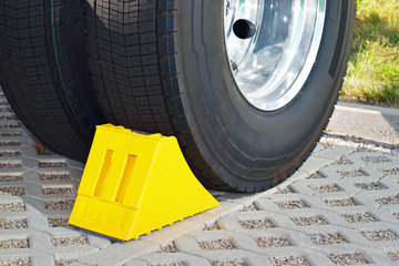 Yellow chock at the wheel of a parked truck 