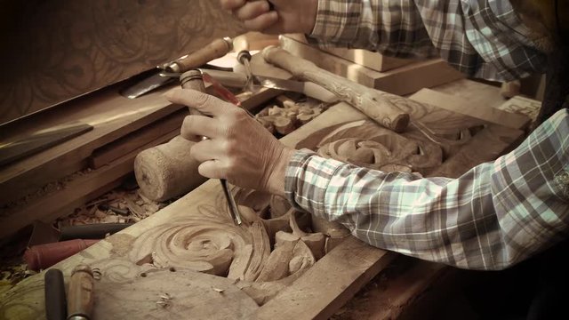 Wood carving. Carver with chisel and hammer. A skillful craftsman working on a panel of wood carve decoration