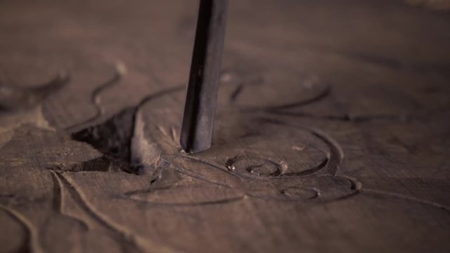Wood carving. Carver with chisel and hammer. A skillful craftsman working on a panel of wood carve decoration