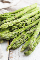 Green asparagus on a wooden white table close-up.