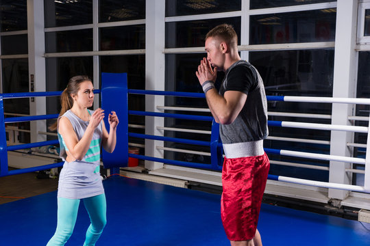 Sporty couple practicing boxing in a boxing ring
