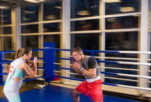Sporty couple in action practicing boxing in a boxing ring
