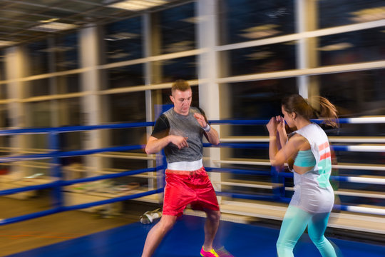 Male and female in action practicing boxing