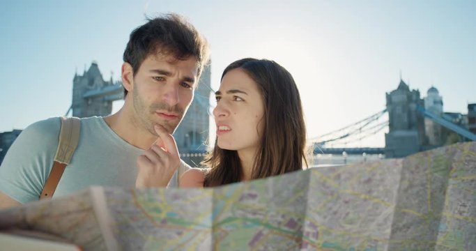 Tourist couple reading City Map planning European holiday Summer Vacation having disagreement fighting over directions
