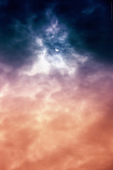 Partial solar eclipse seen through a layer of clouds.