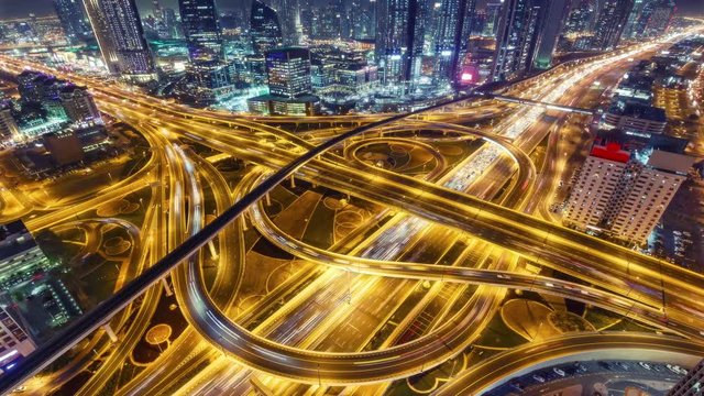 Spectacular nighttime skyline of downtown Dubai. Scenic aerial view of famous highway intersection with traffic. 4K time lapse.