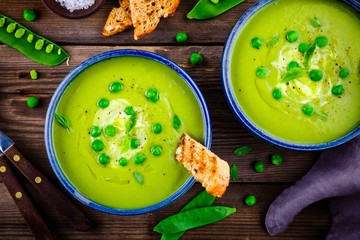Green pea soup on wooden rustic background