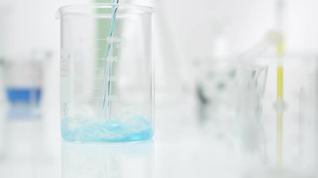 Panning view of blue liquid being poured