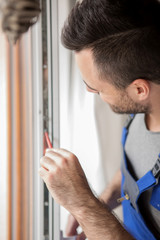 Young handyman repair window
