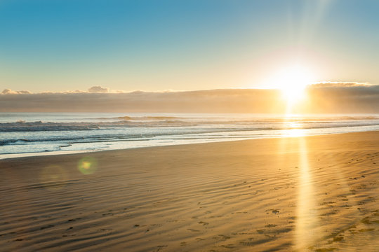 Sunrise over wide flat sandy beach at Ohope Whakatane