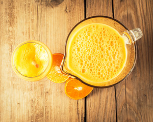 Fresh orange juice on wooden background, top view