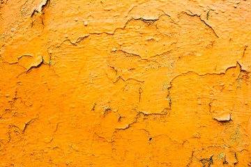 Old wall with dirty broken weathered yellow paint