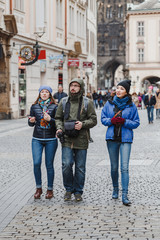 group of happy smiling multiracial friends walking and have fun in the old city of prague. Travel with friends concept