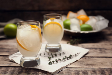 Refreshing cocktails with lemon on wooden table