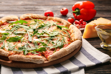 Delicious pizza with ingredients on table