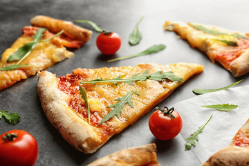 Tasty pizza slices with ingredients on table