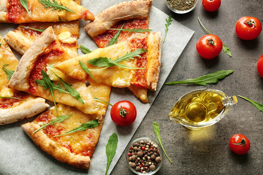 Tasty pizza slices with ingredients on table