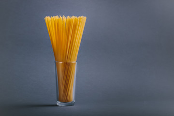 Spaghetti in a glass on neutral background