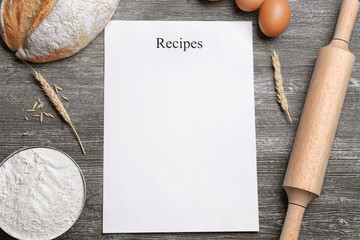 Blank paper sheet and ingredients for cooking bread on wooden background