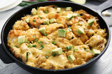 Roasted chicken with cheese in frying pan on kitchen table