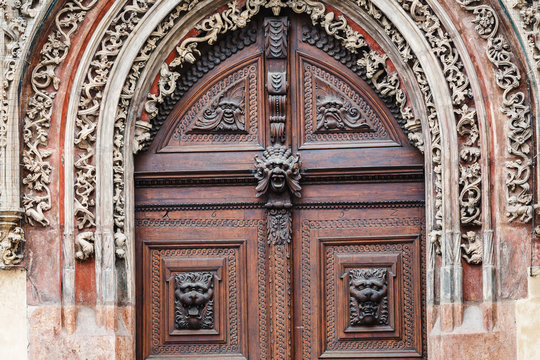 Old door with carved ornaments and frescoes in the temple