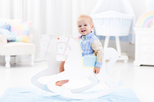 Baby boy in rocking horse toy