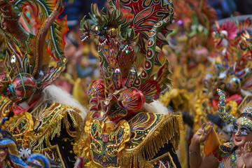Fototapeta na wymiar Masked Diablada dancers in ornate costumes parade through the mining city of Oruro on the Altiplano of Bolivia during the annual carnival.
