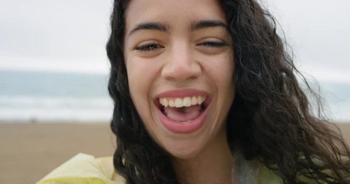 Close up portrait of beautiful african american teenage girl smiling laughing wet hair blowing in wind in rainy weather slow motion