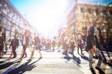 Crowd of anonymous people walking on busy city street