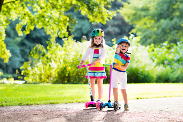 Kids riding scooter in summer park. © famveldman