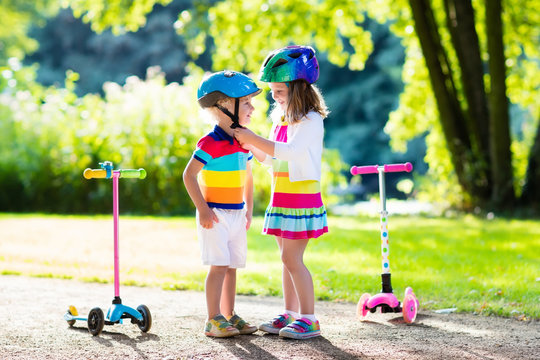 Kids riding scooter in summer park.