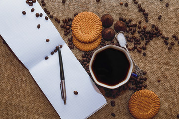 Coffee beans and chocolate candies on sackcloth close up. Coffee and sweets background.