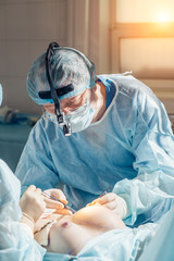 Stitching the patient's skin, the self-extracting threads, after surgery. breast augmentation,...