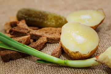 Boiled potatoes in a peel with salt and a green onion on a close-up table. Healthy food.