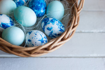 Trendy painted blue easter eggs in a basket