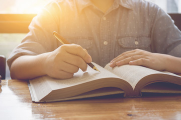 Asian woman reading book,beautiful woman relaxing reading text book in library.serious girl hands holding opened treatise,business woman in meeting room with book case,,selective focus,vintage color..