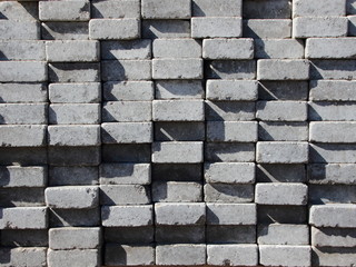 Uneven Stack of Grey Concrete Road Bricks