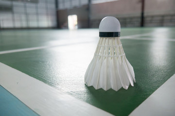 sports concept.Badminton ball (shuttlecock) and racket ,badminton courts with no players competing modern gym in background,selective focus,vintage color