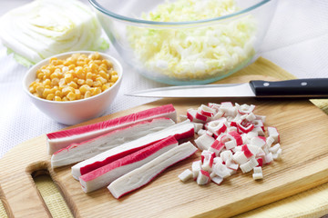 Surimi sticks cut on wooden cutting board.