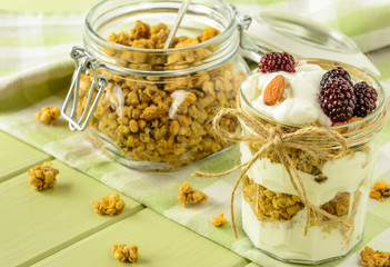 Healthy breakfast ingredients. Homemade granola with yogurt in open glass jar. The food is rich in useful carbohydrates, vitamins and nutrients that are essential for health. 