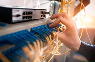 The engineer in a data processing center of ISP Internet Service Provider hold fiber patch cords