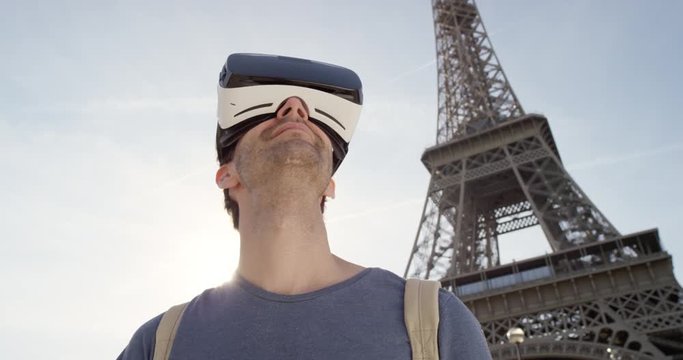 Tourist Man wearing virtual reality headset looking at Eiffel Tower Paris watching 360 video imagination concept