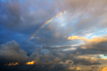 rainbow after the rain in the background of storm clouds