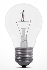 Businesswoman balancing inside lamp