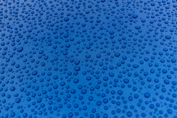 Drops of water on a blue metal surface.
