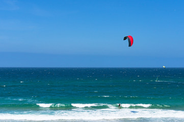 Kitesurfing ocean waves on sunny day