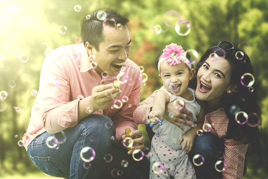 Cheerful family playing soap bubbles