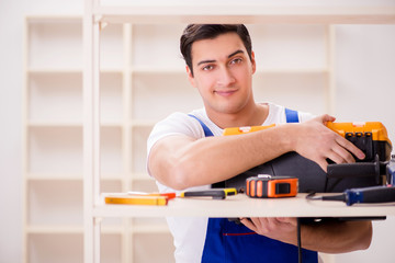 Worker man repairing assembling bookshelf