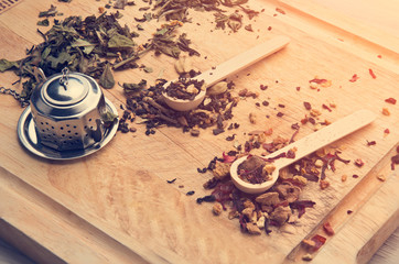 Obraz na płótnie Canvas dried herbal loose tea sitting on wooden cutting board near Asian cup filling air with fragrant aroma, bringing peace, calmness, happiness and mindfulness to all that drink