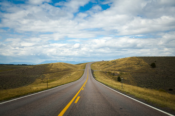 Fototapeta na wymiar Open road with blue sky and clouds, Montana